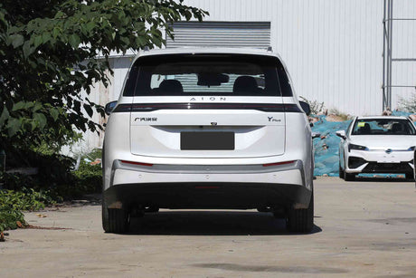 SUV GAC Aion Y Plus отзад, паркиран пред модерна сграда, подчертаващ футуристичен дизайн.