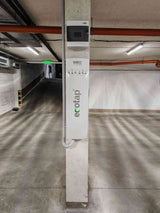 Ecotap Duo WallCharger 22kW монтирана на стълб в гараж, с централизирано електрическо табло за управление на зареждането.
